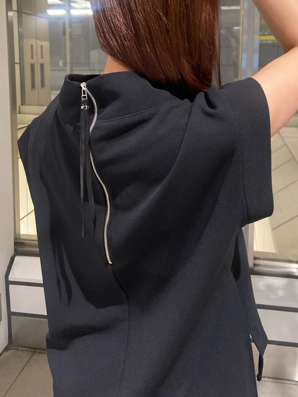 ブラック系のTシャツ/カットソー、ベージュ系のスカート、ホワイト系のサンダルを着用したレディースの春コーディネートの5枚目の写真