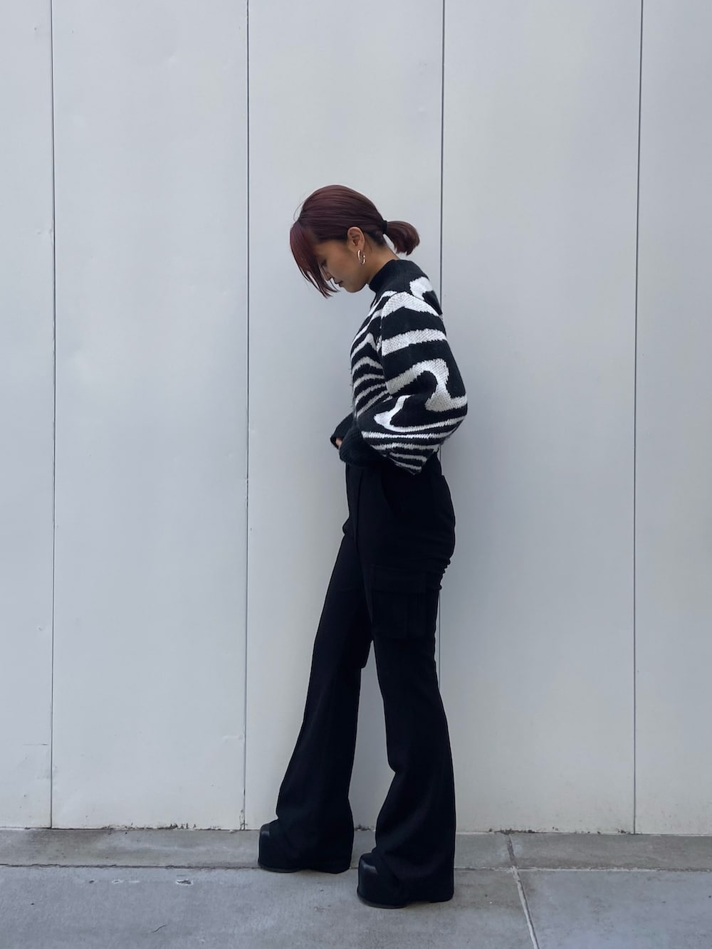 ブラック系のニット/セーター、ブラック系のカーゴパンツ、ブラック系のブーツを着用したレディースの冬コーディネートの2枚目の写真