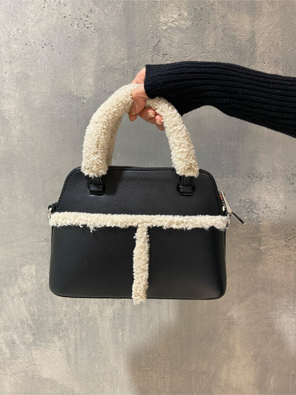 ブラック系のブーツ、ブラック系のワンピース、ブラック系のショルダーバッグを着用したレディースの冬コーディネートの7枚目の写真