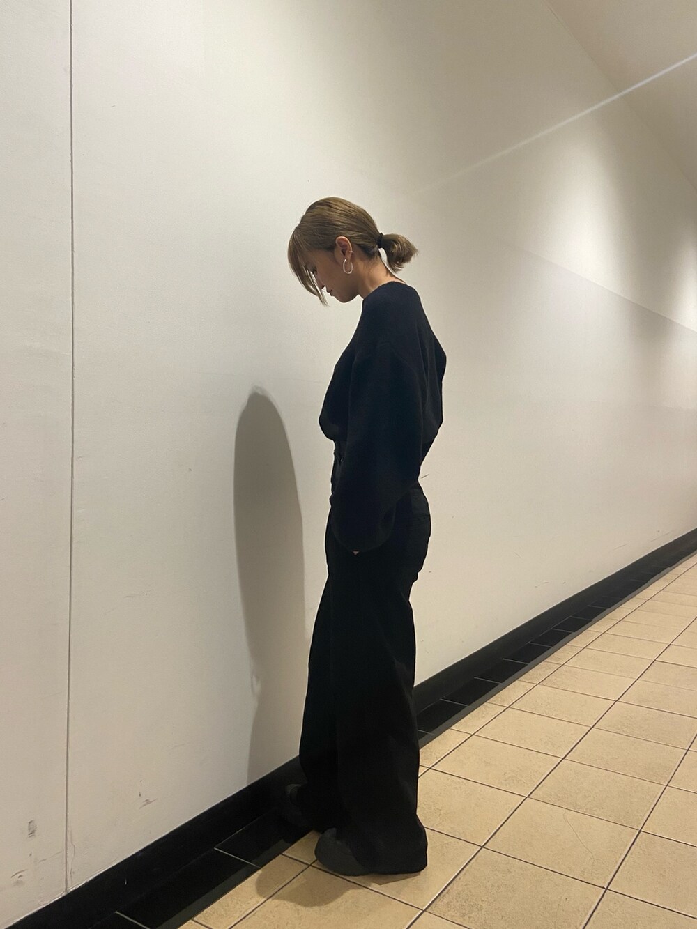 ブラック系のブーツ、ブルー系のニット/セーター、ブラック系のデニムパンツを着用したレディースの冬コーディネートの3枚目の写真