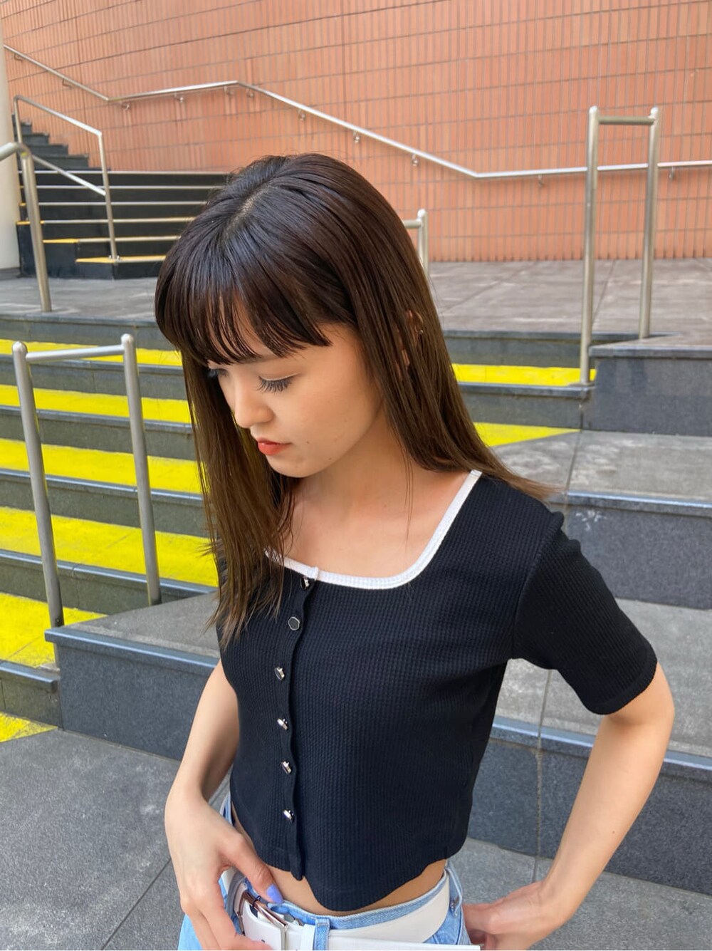 ブラック系のサンダル、ブルー系のデニムパンツ、ブラック系のTシャツ/カットソーを着用したレディースの春コーディネートの4枚目の写真