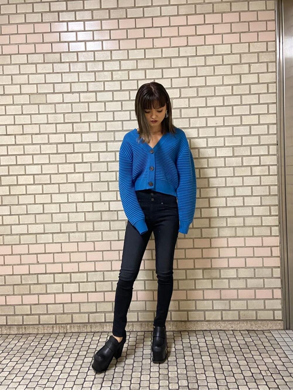 ブラック系のローファー、ブラック系のデニムパンツ、ブルー系のニット/セーターを着用したレディースの冬コーディネートの2枚目の写真