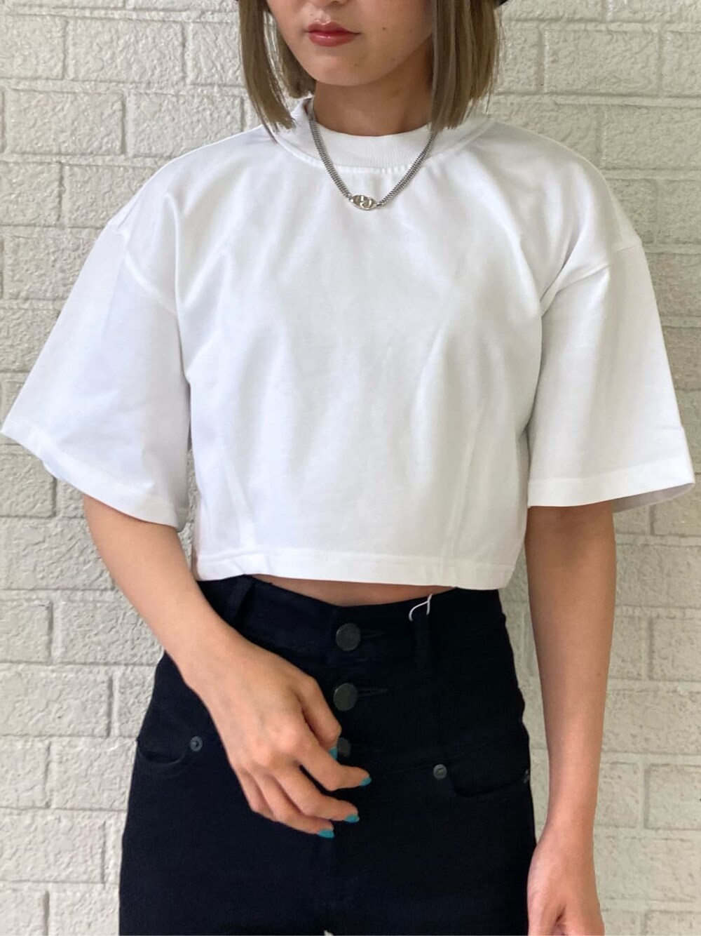 ブラック系のデニムパンツ、ブラック系のサンダル、ホワイト系のTシャツ/カットソーを着用したレディースの夏コーディネートの5枚目の写真