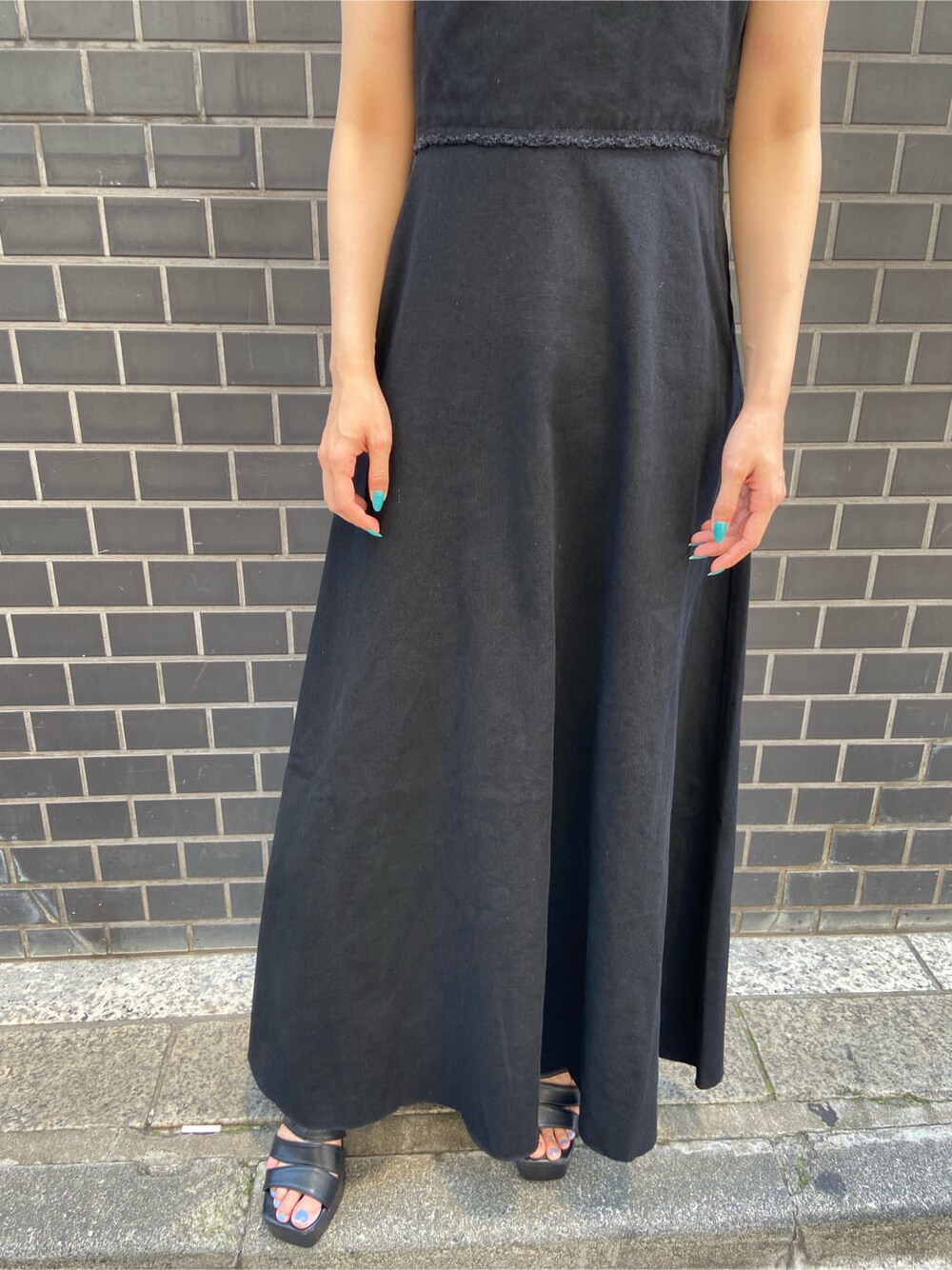 ブラック系のワンピース、ブラック系のサンダル、ブラック系のタンクトップを着用したレディースの夏コーディネートの4枚目の写真