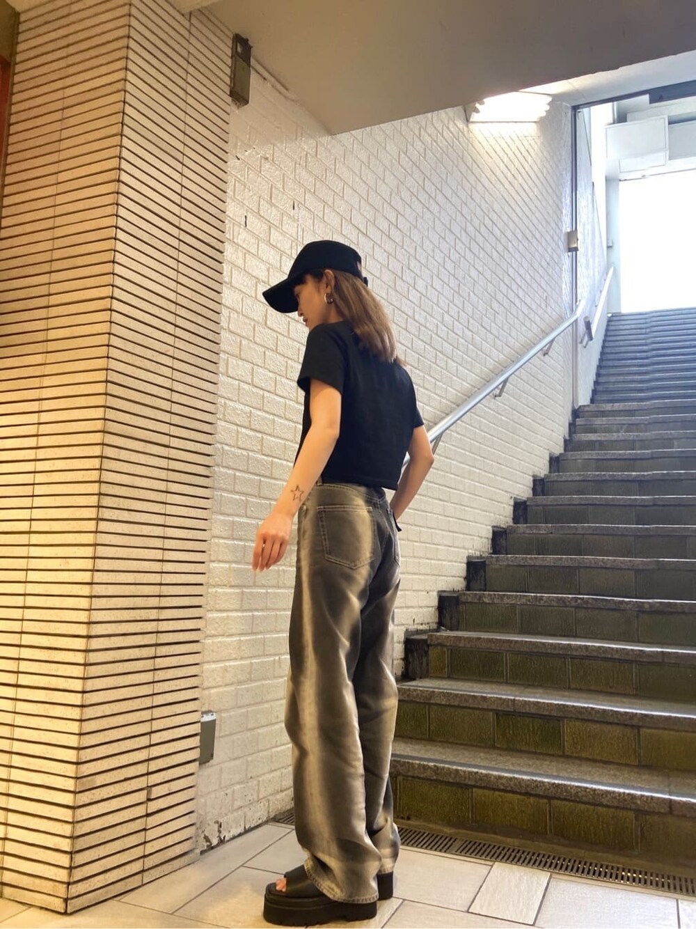 ブラック系のサンダル、ブラック系のデニムパンツ、ブラック系のTシャツ/カットソーを着用したレディースの春コーディネートの3枚目の写真