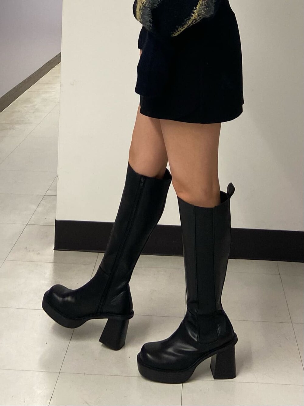 ブラック系のブーツ、ブラック系のスカート、ブラック系のテーラードジャケットを着用したレディースの秋コーディネートの8枚目の写真