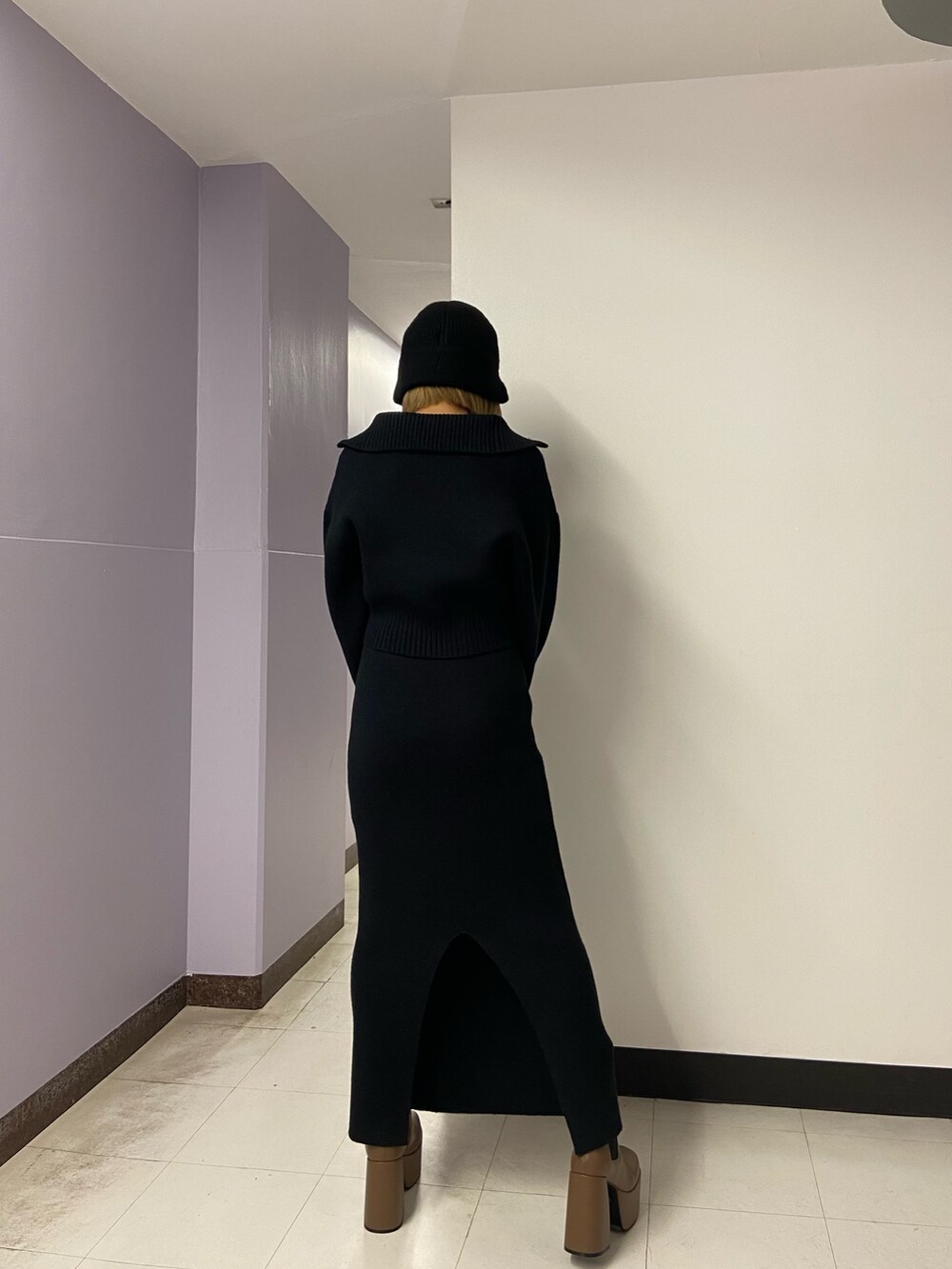 ブラック系のニット/セーター、ブラウン系のブーツ、ブラック系のスカートを着用したレディースの冬コーディネートの4枚目の写真