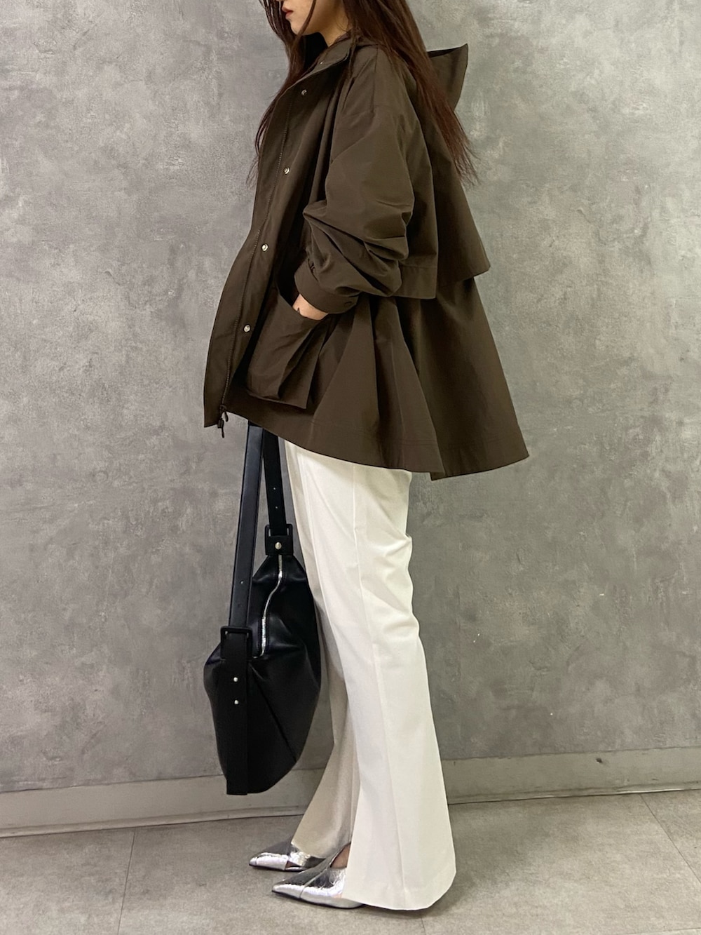 ブラウン系のブルゾン、ブラック系のTシャツ/カットソー、ブラック系のショルダーバッグを着用したレディースの冬コーディネートの2枚目の写真