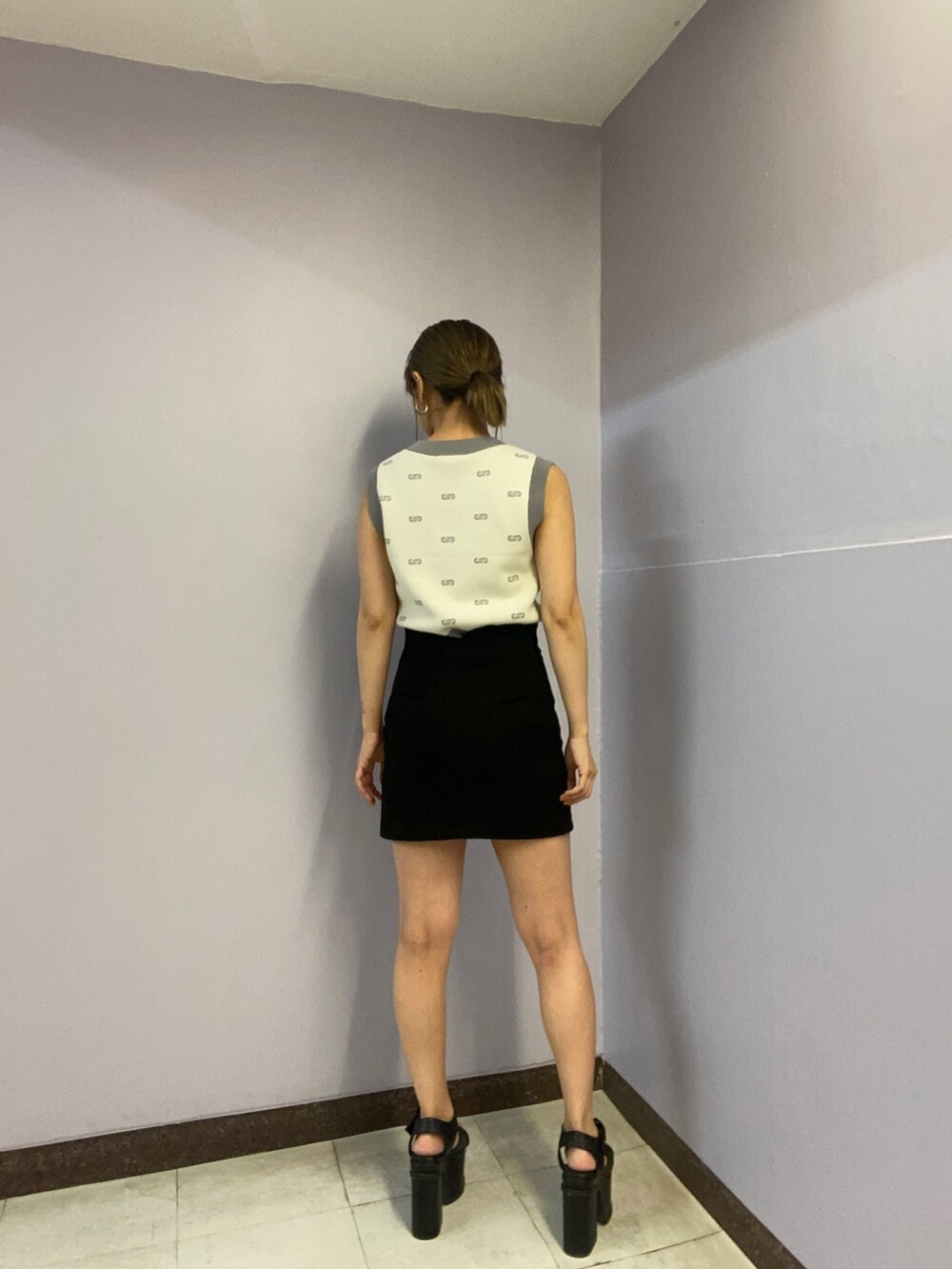 ホワイト系のニット/セーター、ブラック系のスカート、ブラック系のサンダルを着用したレディースの春コーディネートの3枚目の写真