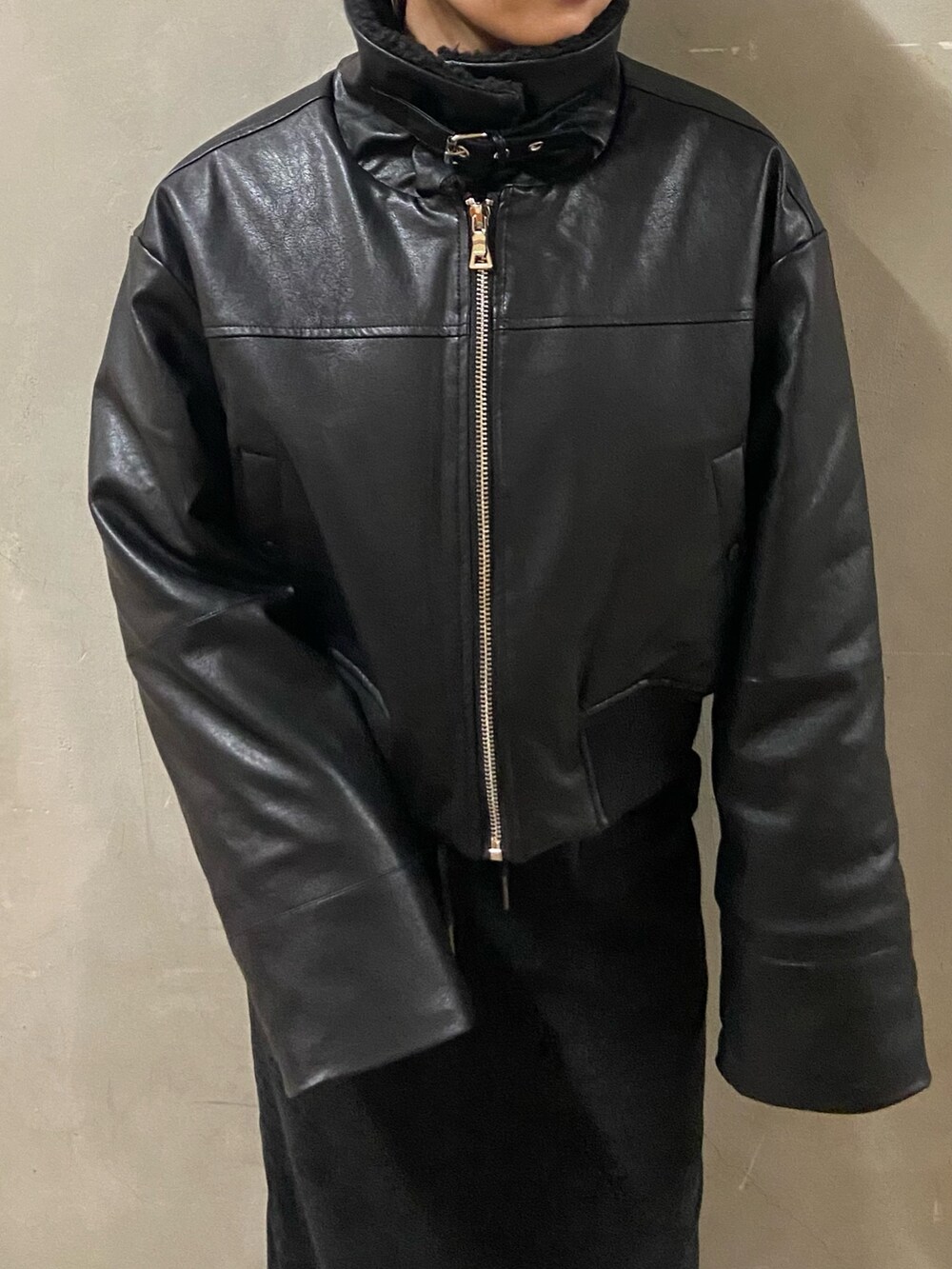 ブラック系のブルゾン、ブラック系のスカート、ブラック系のブーツを着用したレディースの秋コーディネートの5枚目の写真