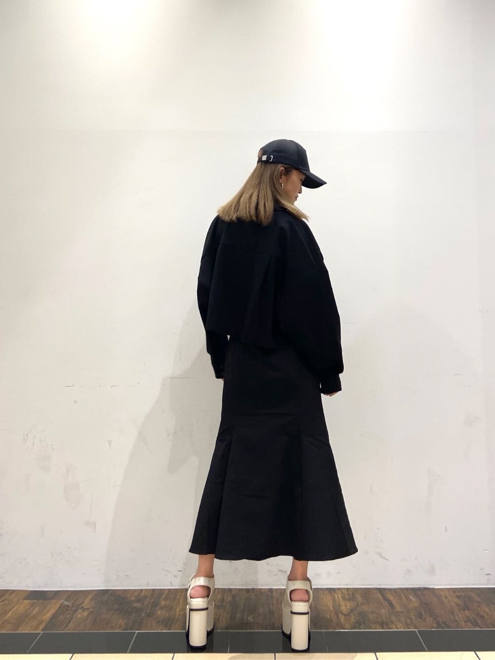 ブラック系のブルゾン、ホワイト系のサンダル、ブラック系のスカートを着用したレディースの春コーディネートの3枚目の写真