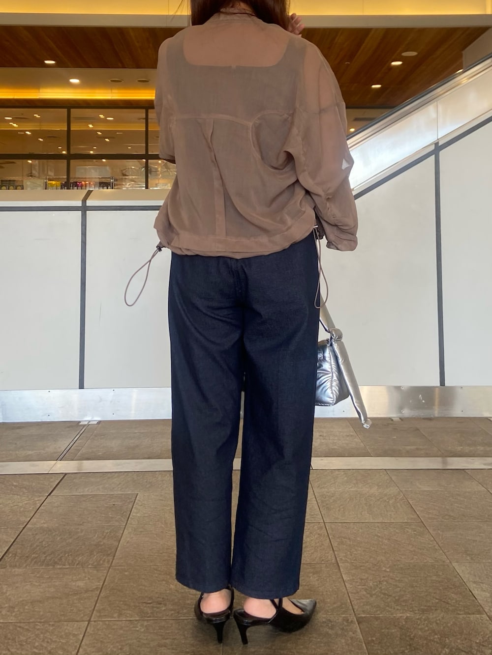 ベージュ系のブルゾン、シルバー系のハンドバッグ、ブラック系のサンダルを着用したレディースの春コーディネートの3枚目の写真