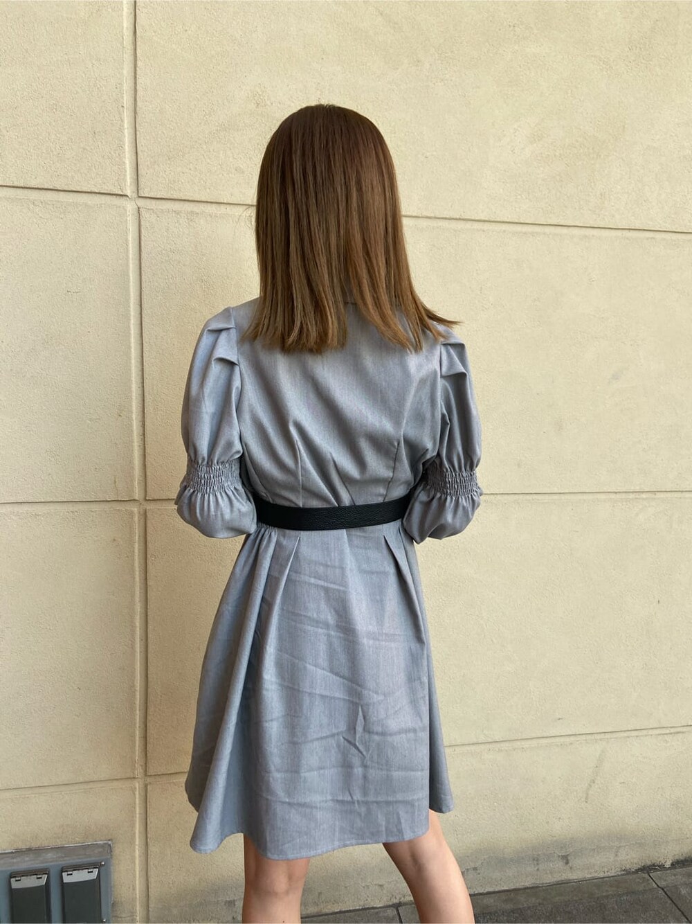 ブラック系のブーツ、グレー系のワンピース、シルバー系のピアス（両耳用）を着用したレディースの春コーディネートの6枚目の写真