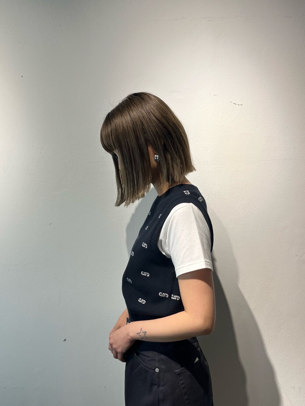 ホワイト系のTシャツ/カットソー、ブラック系のデニムパンツ、ホワイト系のサンダルを着用したレディースの春コーディネートの7枚目の写真