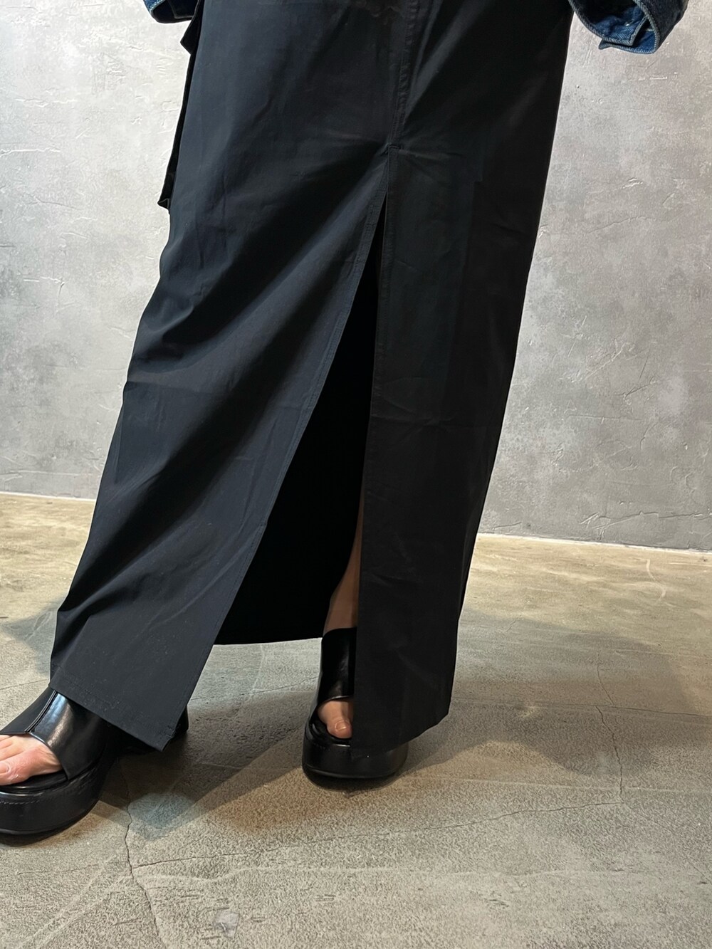 ブルー系のデニムジャケット、ベージュ系のキャミソール、ブラック系のスカートを着用したレディースの春コーディネートの6枚目の写真