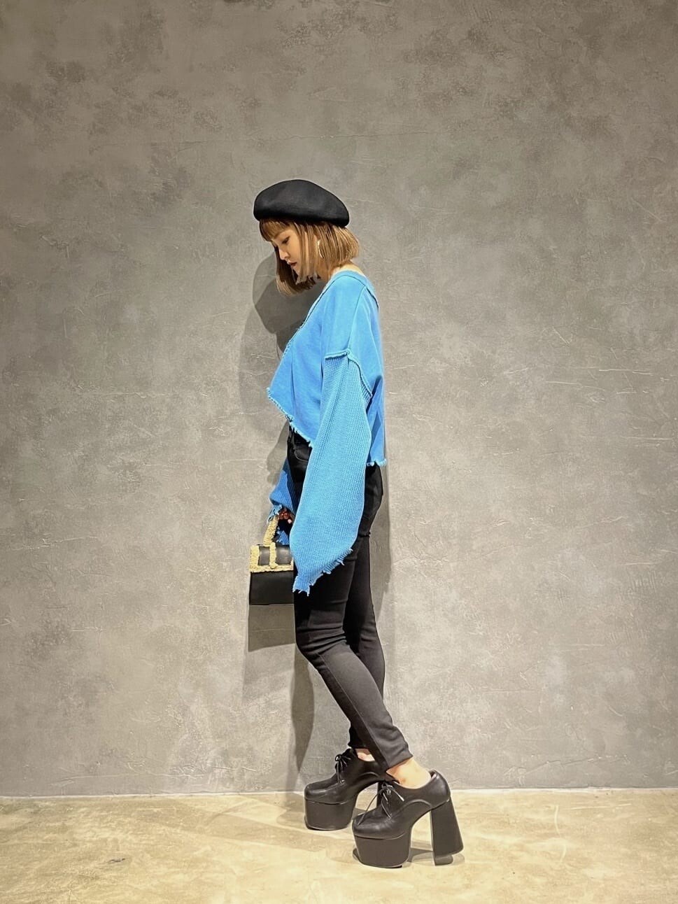 ブラック系のデニムパンツ、ブラック系のハンドバッグ、ブルー系のカーディガン/ボレロを着用したレディースの秋コーディネートの2枚目の写真