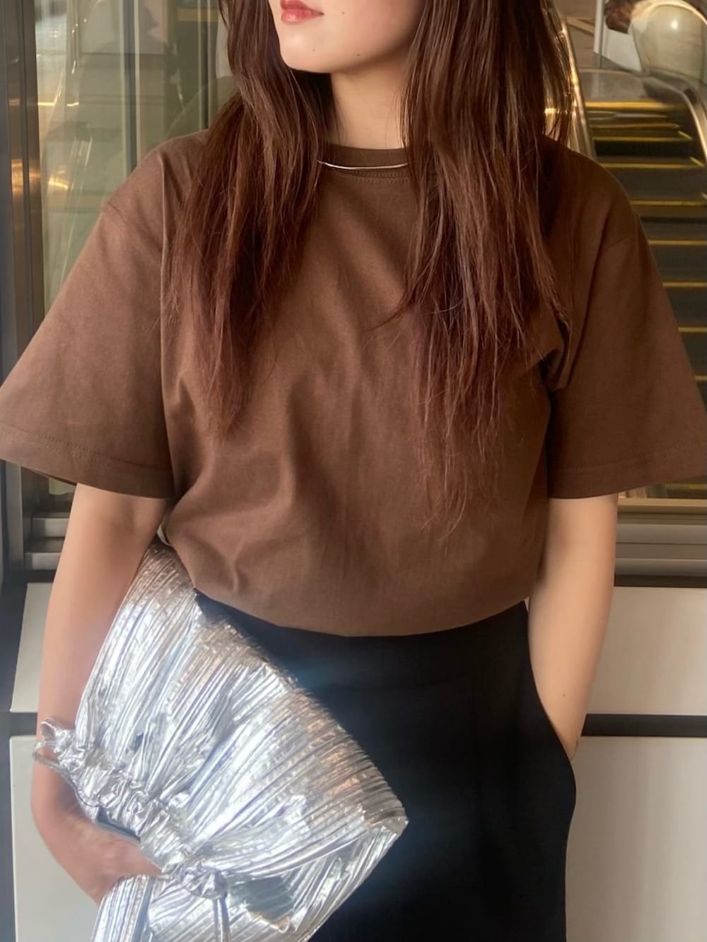 ブラック系のスカート、ブラウン系のTシャツ/カットソー、ホワイト系のサンダルを着用したレディースの春コーディネートの4枚目の写真