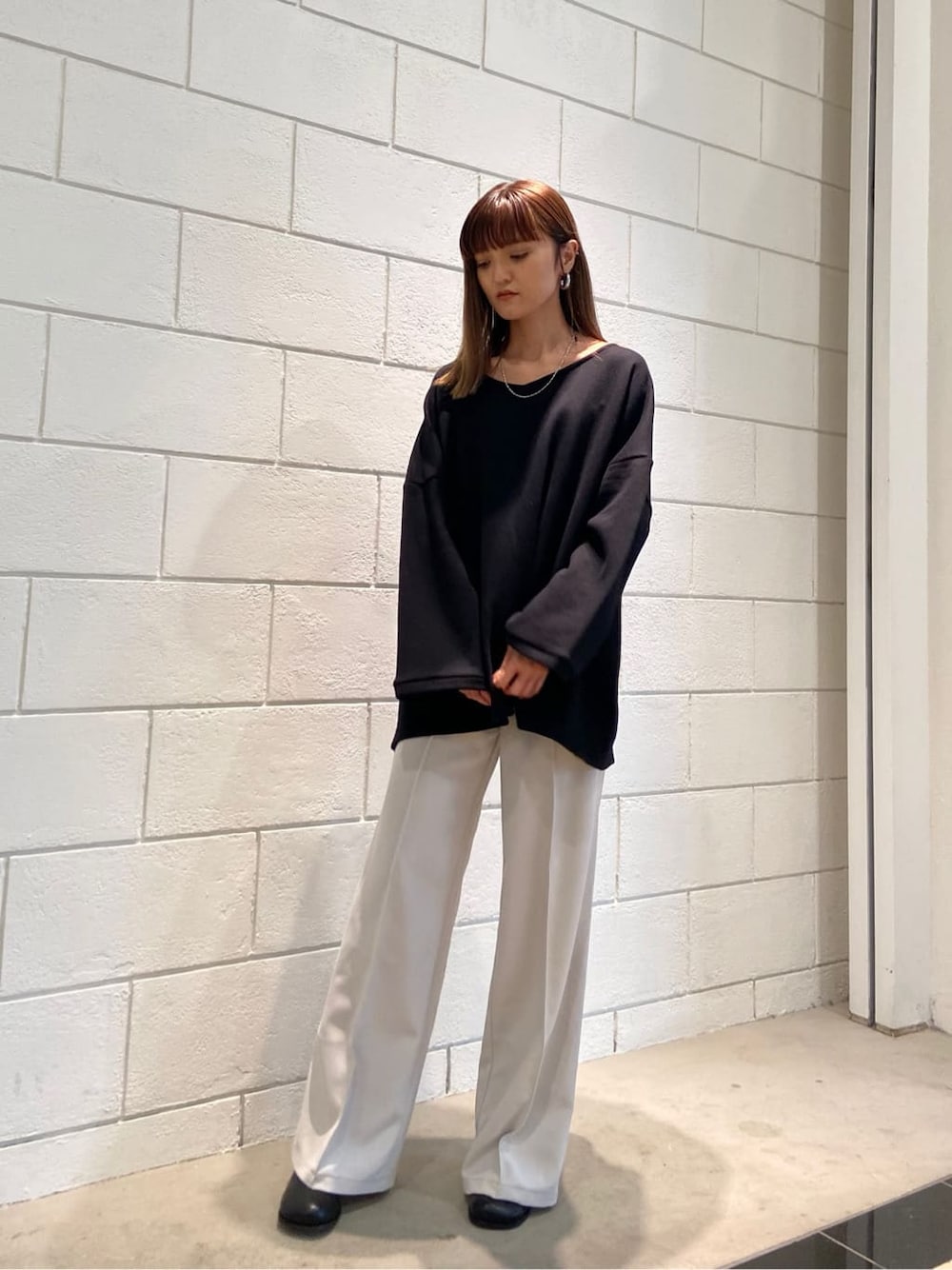 ホワイト系のその他パンツ、ブラック系のブーツ、ブラック系のTシャツ/カットソーを着用したレディースの春コーディネートの2枚目の写真