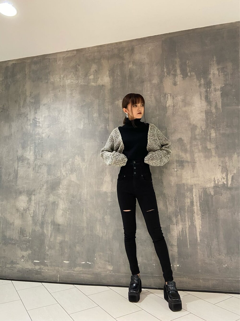 ブラック系のローファー、ブラック系のニット/セーター、ブラック系のデニムパンツを着用したレディースの秋コーディネートの2枚目の写真