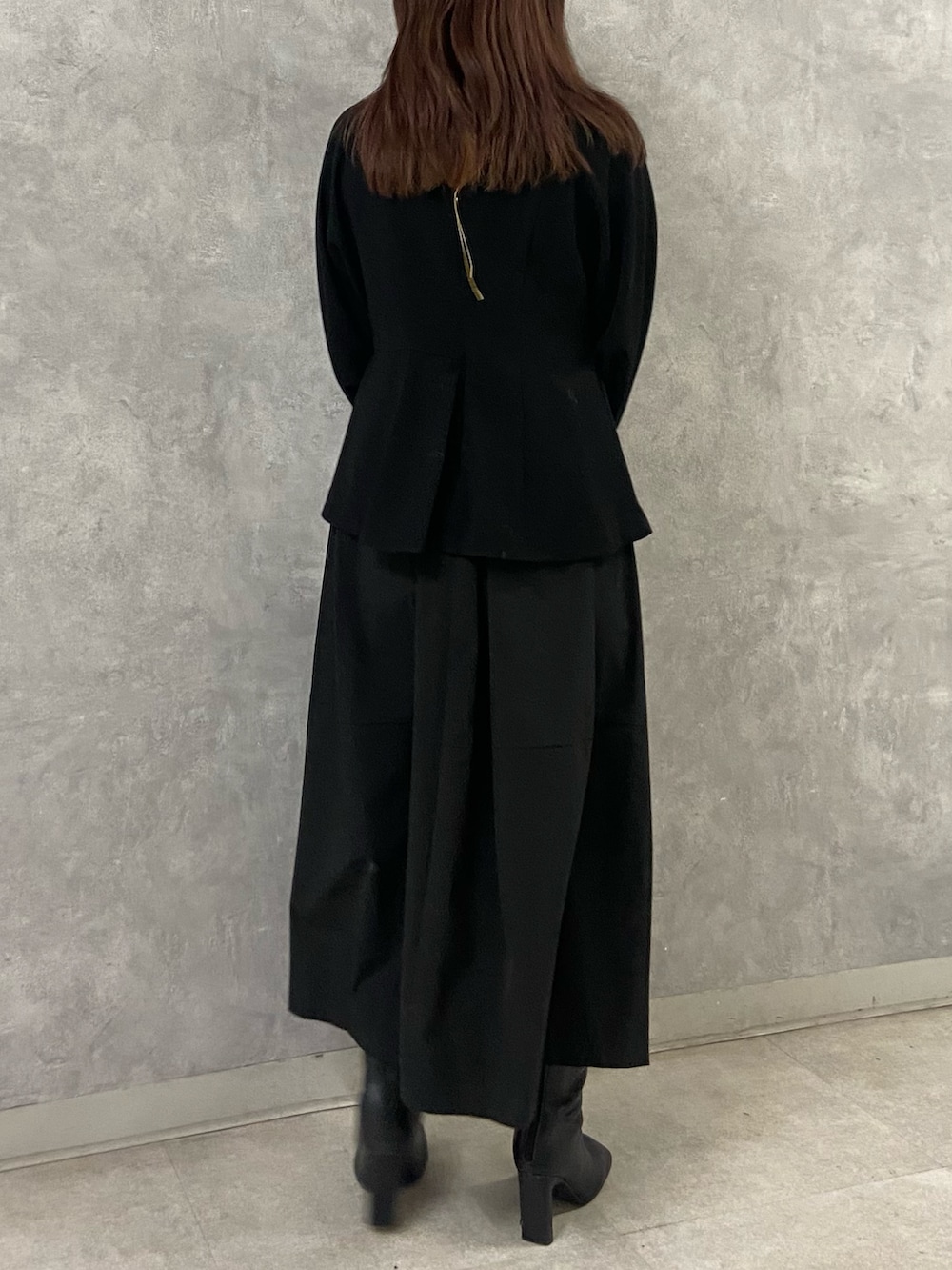 ホワイト系のブルゾン、ブラック系のワンピース、ブラック系のブーツを着用したレディースの冬コーディネートの8枚目の写真