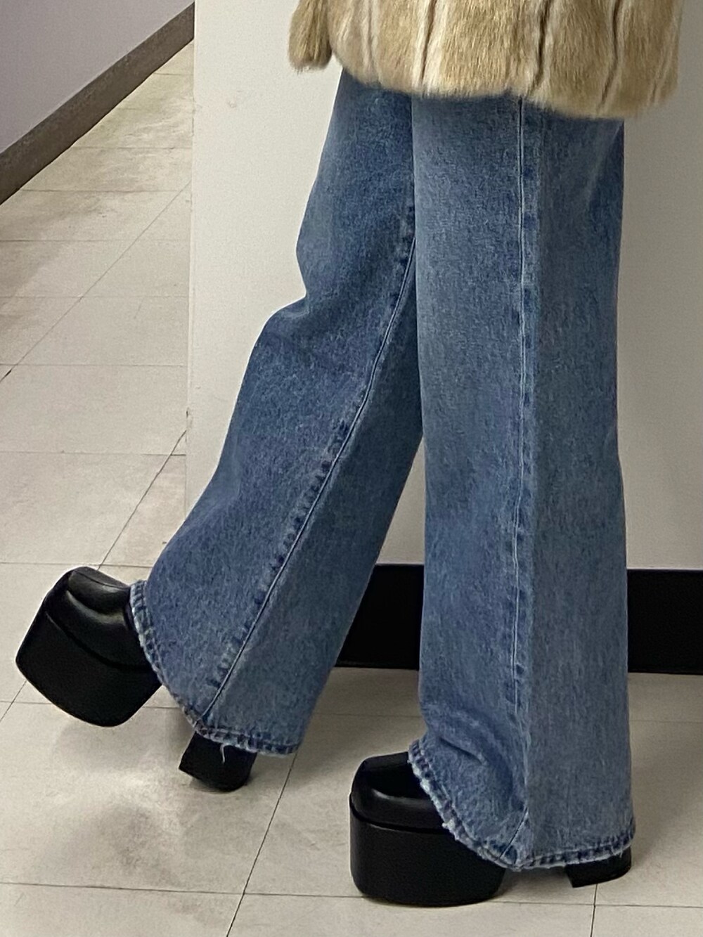 ベージュ系のその他アウター、ブラック系のニット/セーター、ブルー系のデニムパンツを着用したレディースの冬コーディネートの7枚目の写真