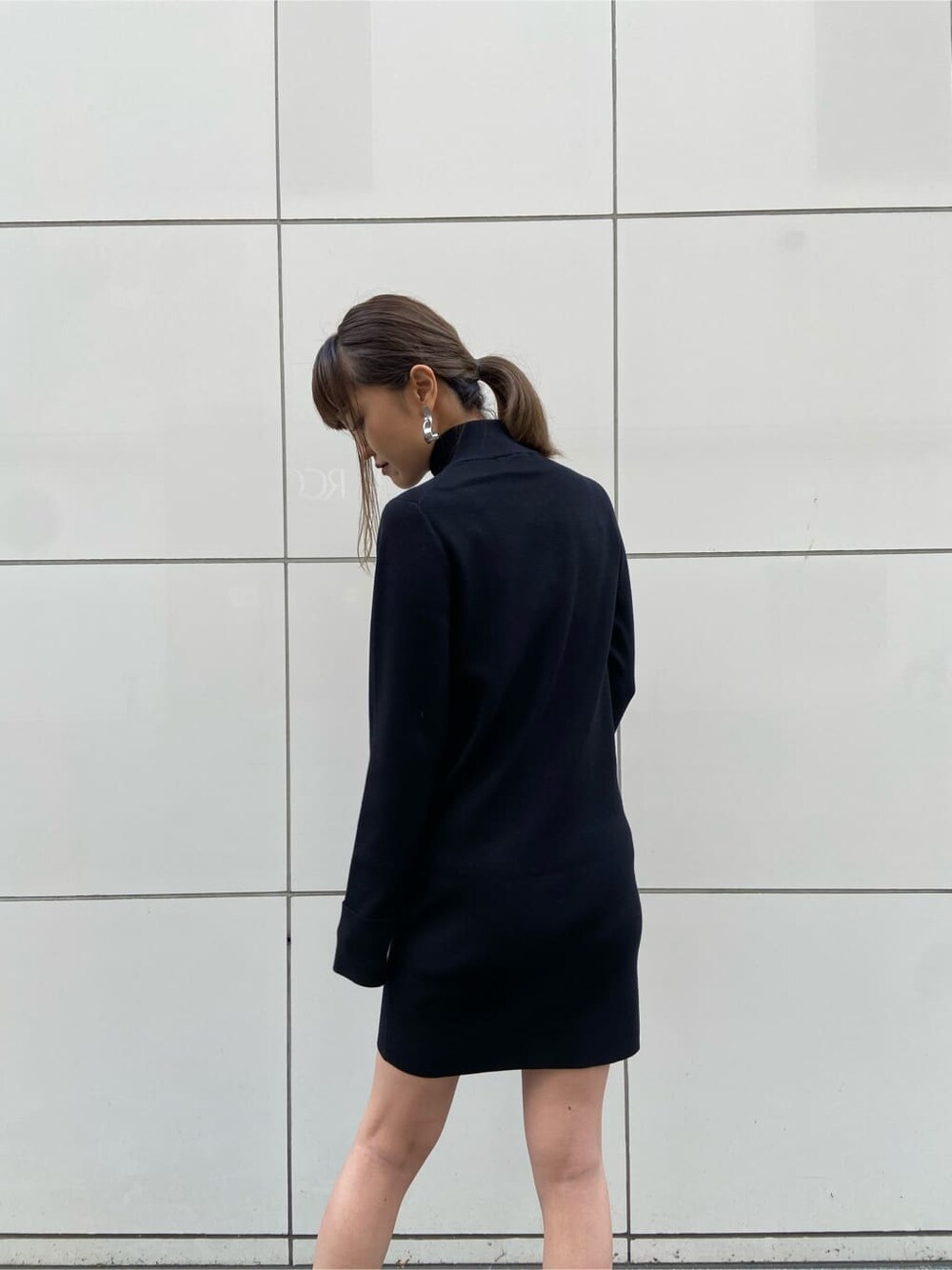 ブラック系のワンピース、ブラック系のブーツを着用したレディースの冬コーディネートの2枚目の写真