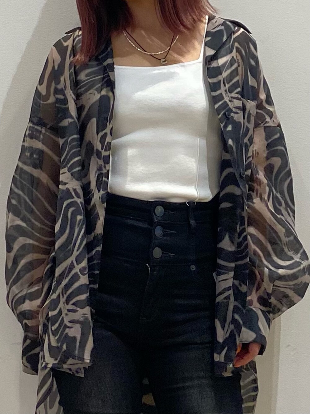 ブラック系のデニムパンツ、ブラック系のサンダル、ホワイト系のタンクトップを着用したレディースの春コーディネートの3枚目の写真