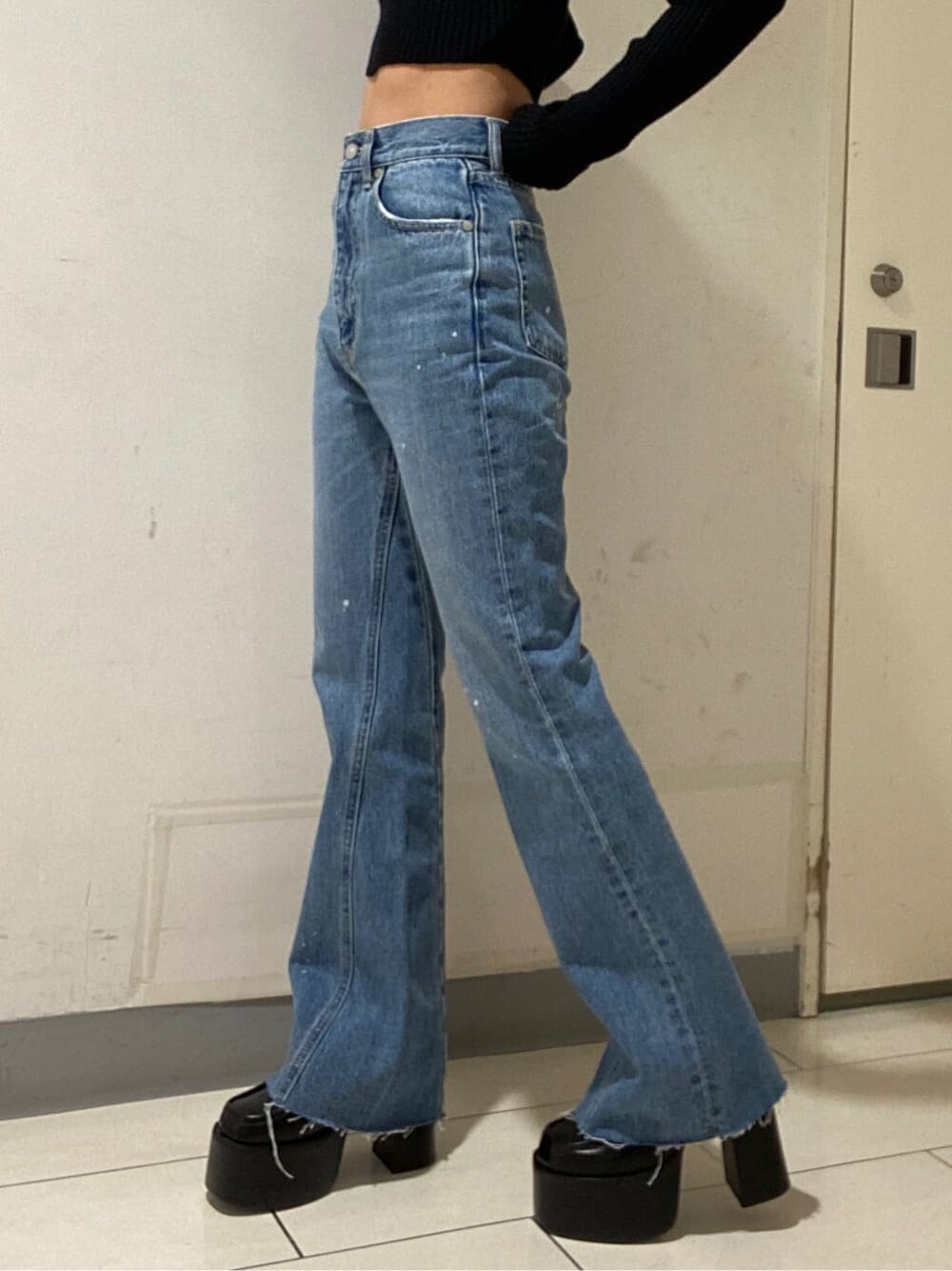 ブラック系のニット/セーター、ブルー系のデニムパンツ、ブラック系のローファーを着用したレディースの冬コーディネートの4枚目の写真