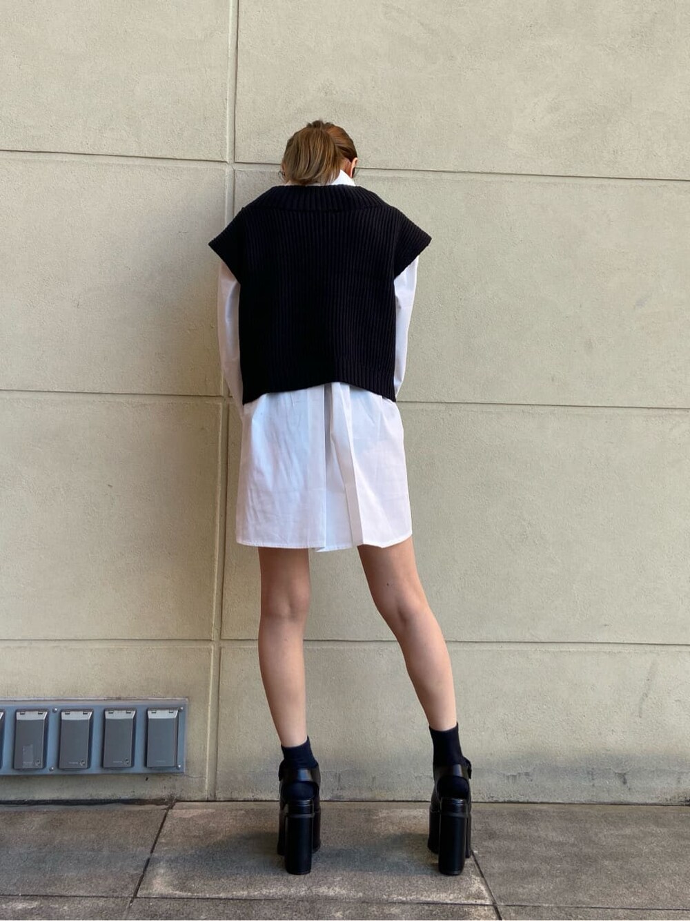 ホワイト系のシャツ/ブラウス、ブラック系のベスト、ブラック系のサンダルを着用したレディースの春コーディネートの3枚目の写真