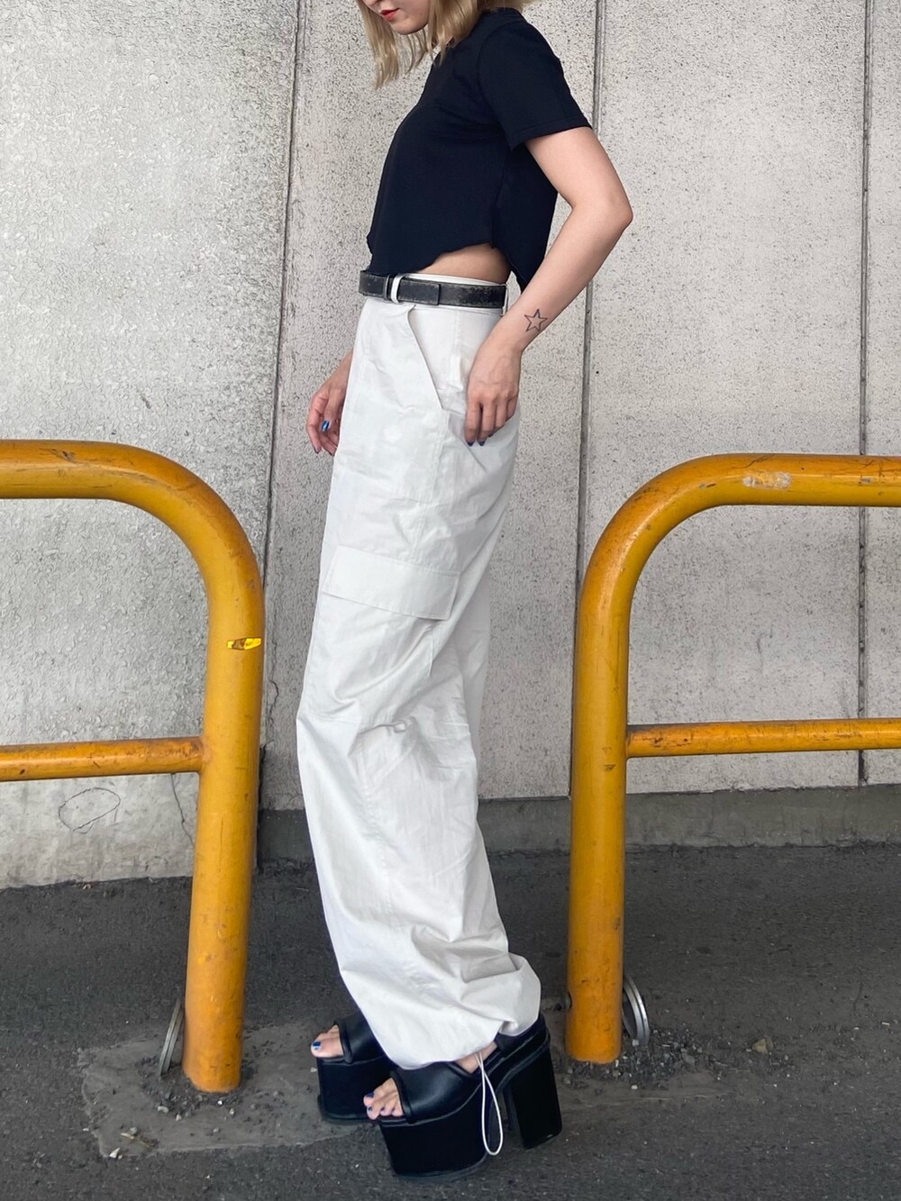 ブラック系のTシャツ/カットソー、ホワイト系のカーゴパンツ、ブラック系のサンダルを着用したレディースの夏コーディネートの3枚目の写真