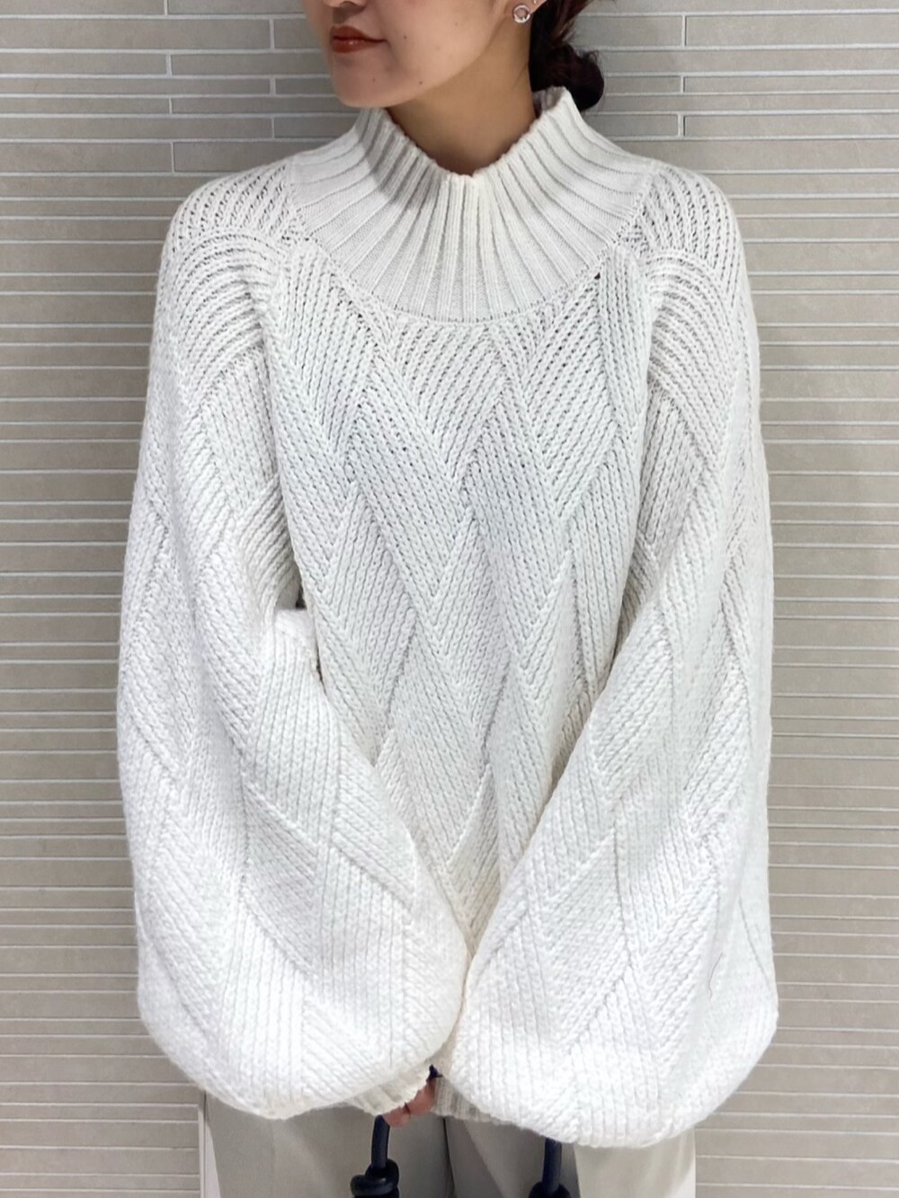 ホワイト系のニット/セーター、ホワイト系のその他パンツ、ブラック系のブーツを着用したレディースの秋コーディネートの5枚目の写真