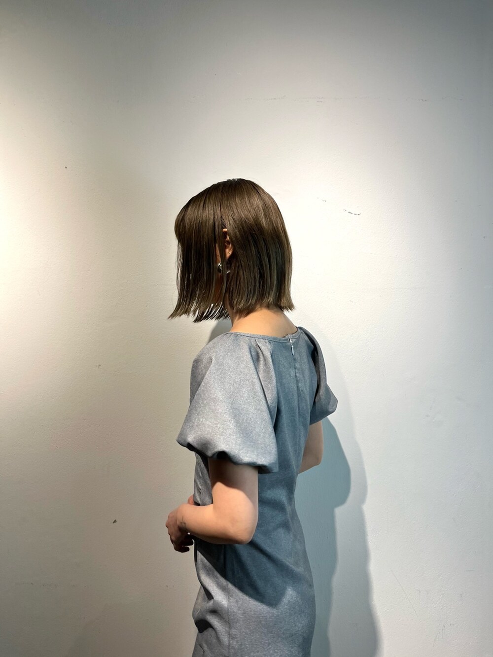 グレー系のワンピース、ホワイト系のサンダルを着用したレディースの春コーディネートの5枚目の写真