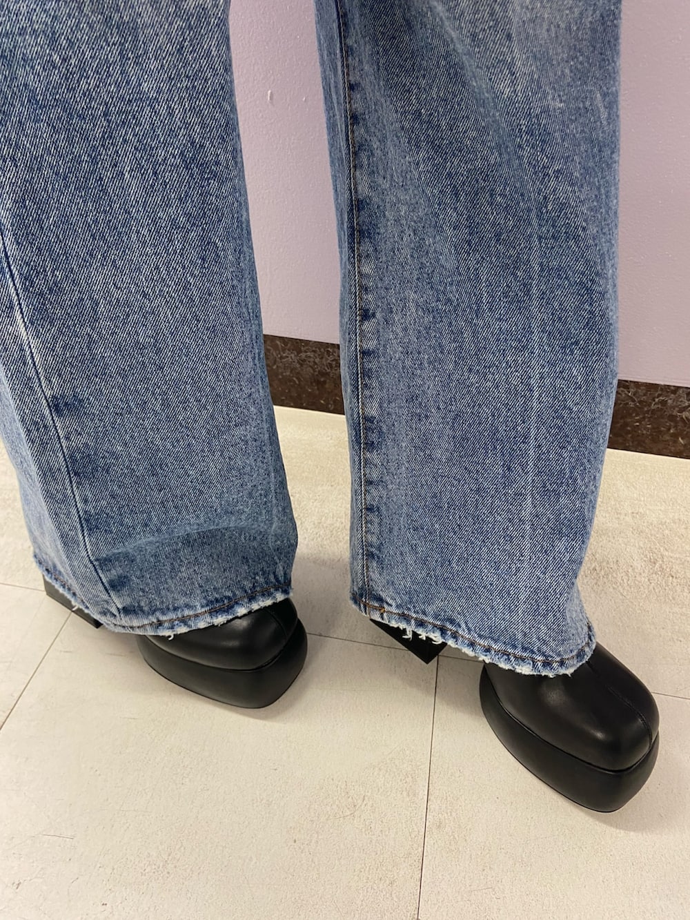 ブルー系のデニムパンツ、ブラック系のブーツ、ホワイト系のスウェットを着用したレディースの秋コーディネートの7枚目の写真