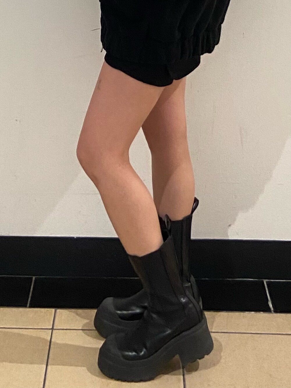 ブラック系のブルゾン、ブラック系のスカート、ブラック系のブーツを着用したレディースの秋コーディネートの5枚目の写真