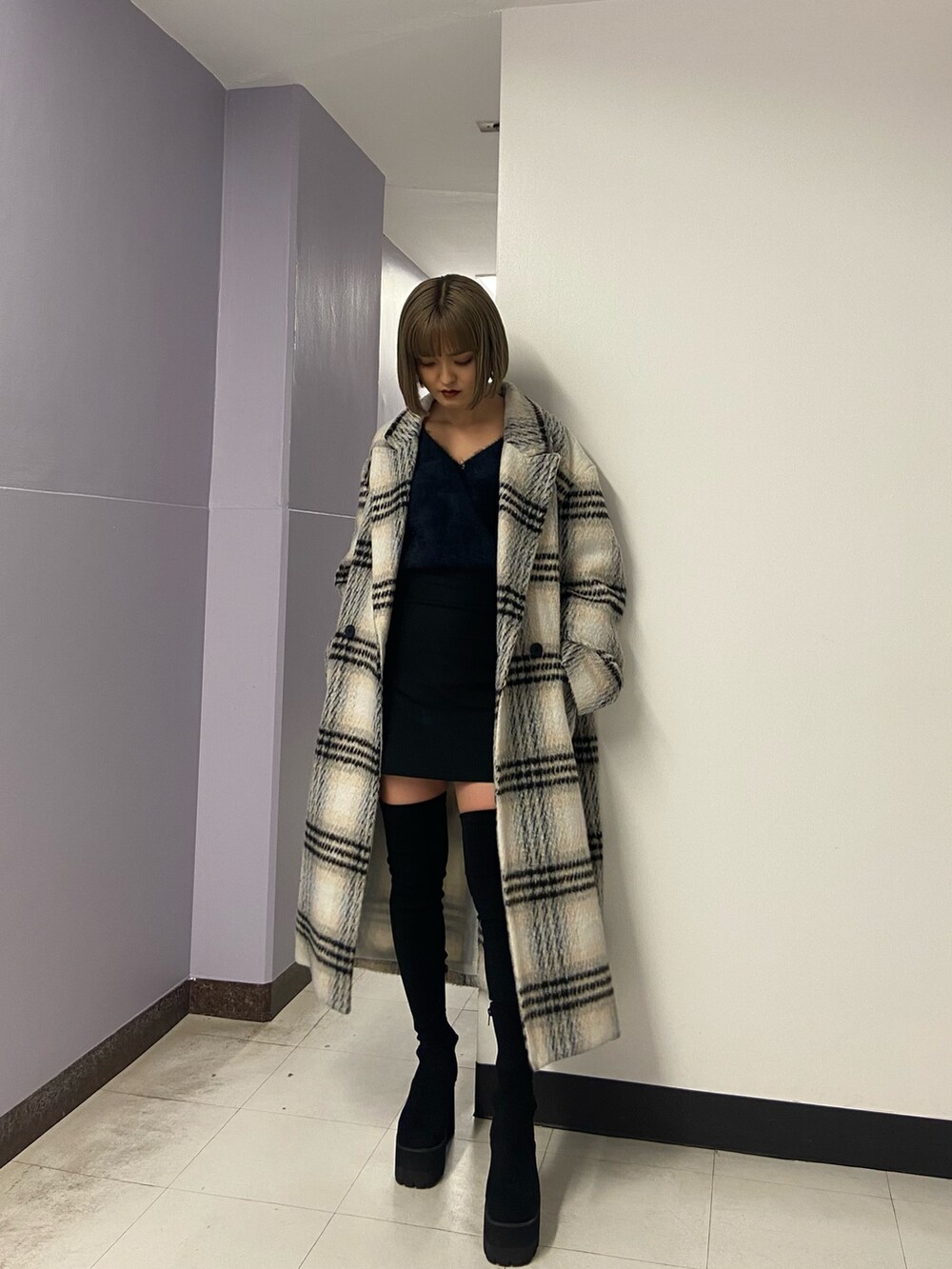 ブラック系のブーツ、ブラック系のスカート、その他のチェスターコートを着用したレディースの冬コーディネートの2枚目の写真