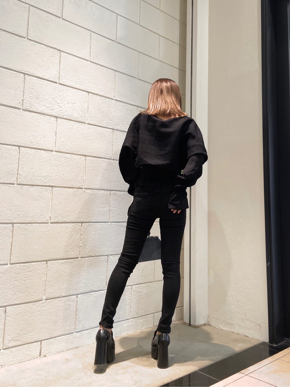 ブラック系のローファー、ブルー系のハンドバッグ、ブラック系のシャツ/ブラウスを着用したレディースの冬コーディネートの3枚目の写真