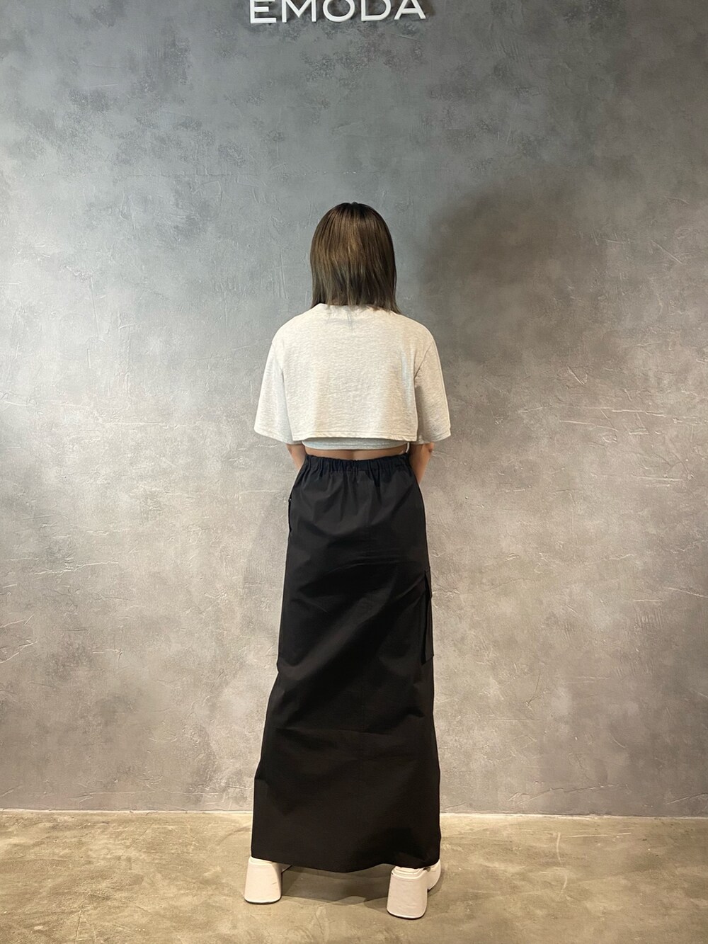 グレー系のTシャツ/カットソー、ホワイト系のサンダル、ブラック系のスカートを着用したレディースの春コーディネートの4枚目の写真