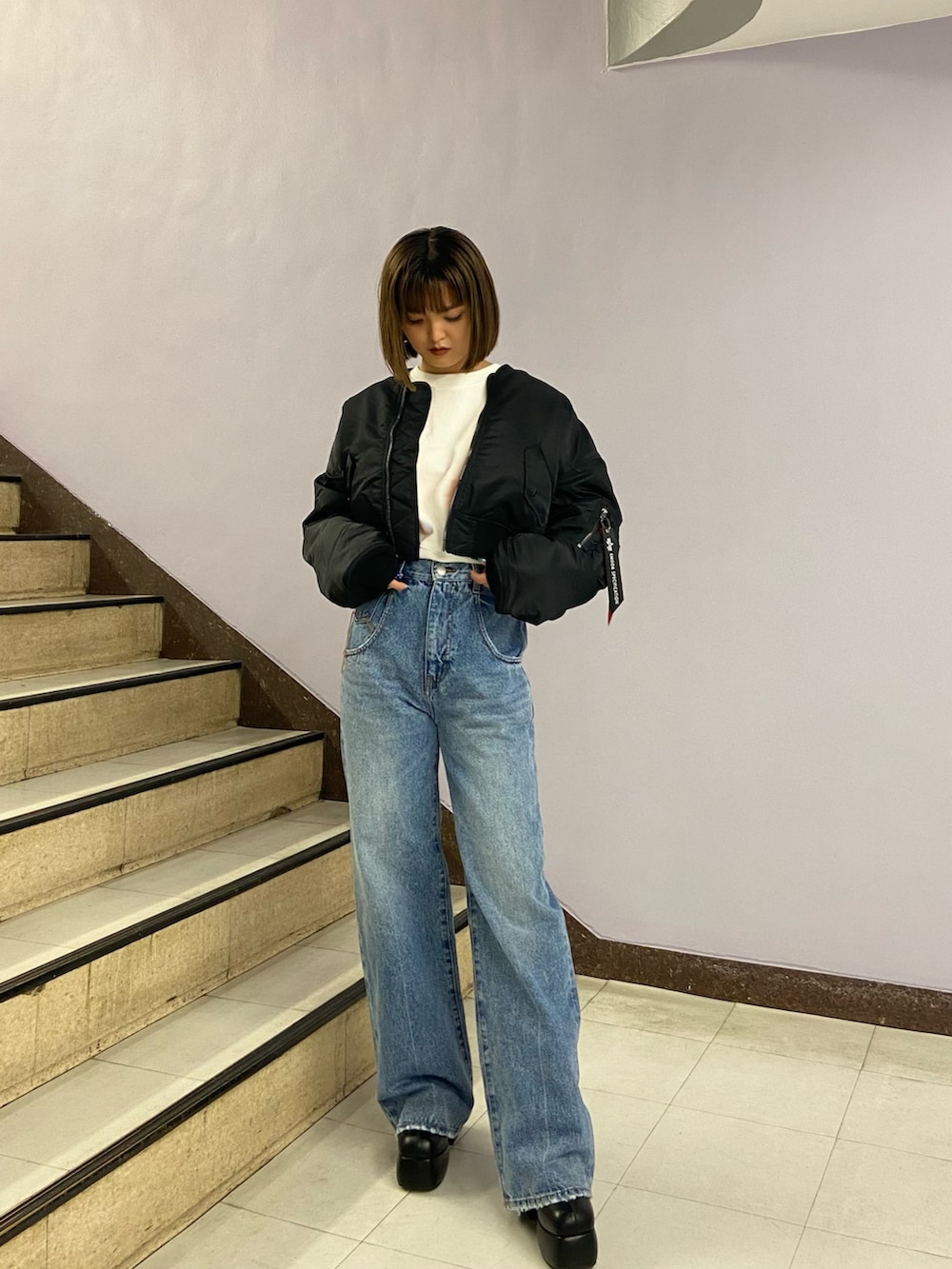 ブルー系のデニムパンツ、ブラック系のブーツ、ホワイト系のスウェットを着用したレディースの秋コーディネートの2枚目の写真