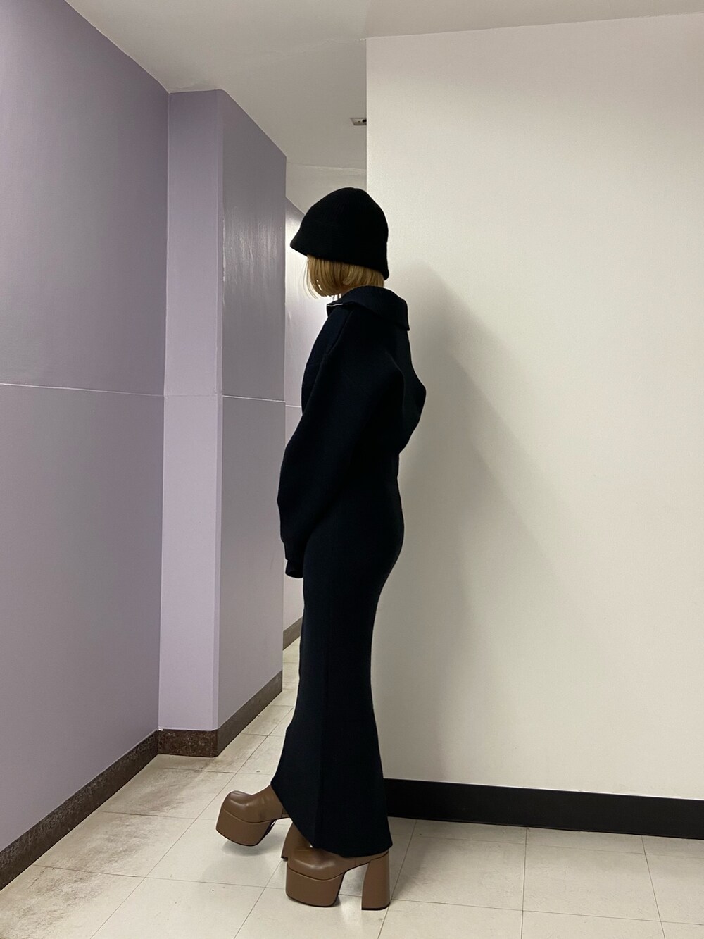 ブラック系のニット/セーター、ブラウン系のブーツ、ブラック系のスカートを着用したレディースの冬コーディネートの3枚目の写真