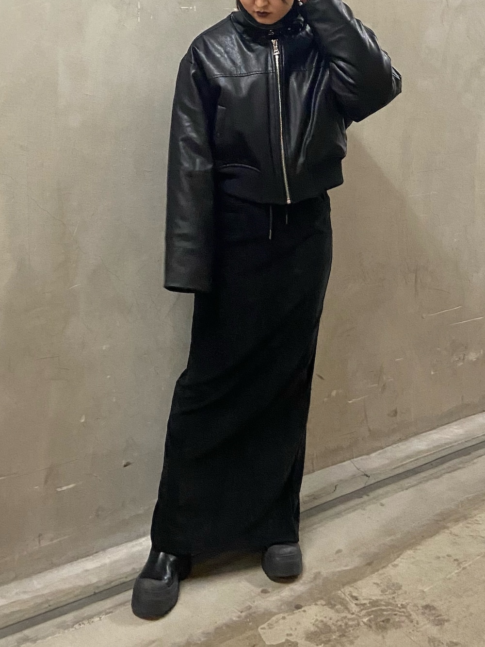 ブラック系のブルゾン、ブラック系のスカート、ブラック系のブーツを着用したレディースの秋コーディネートの2枚目の写真