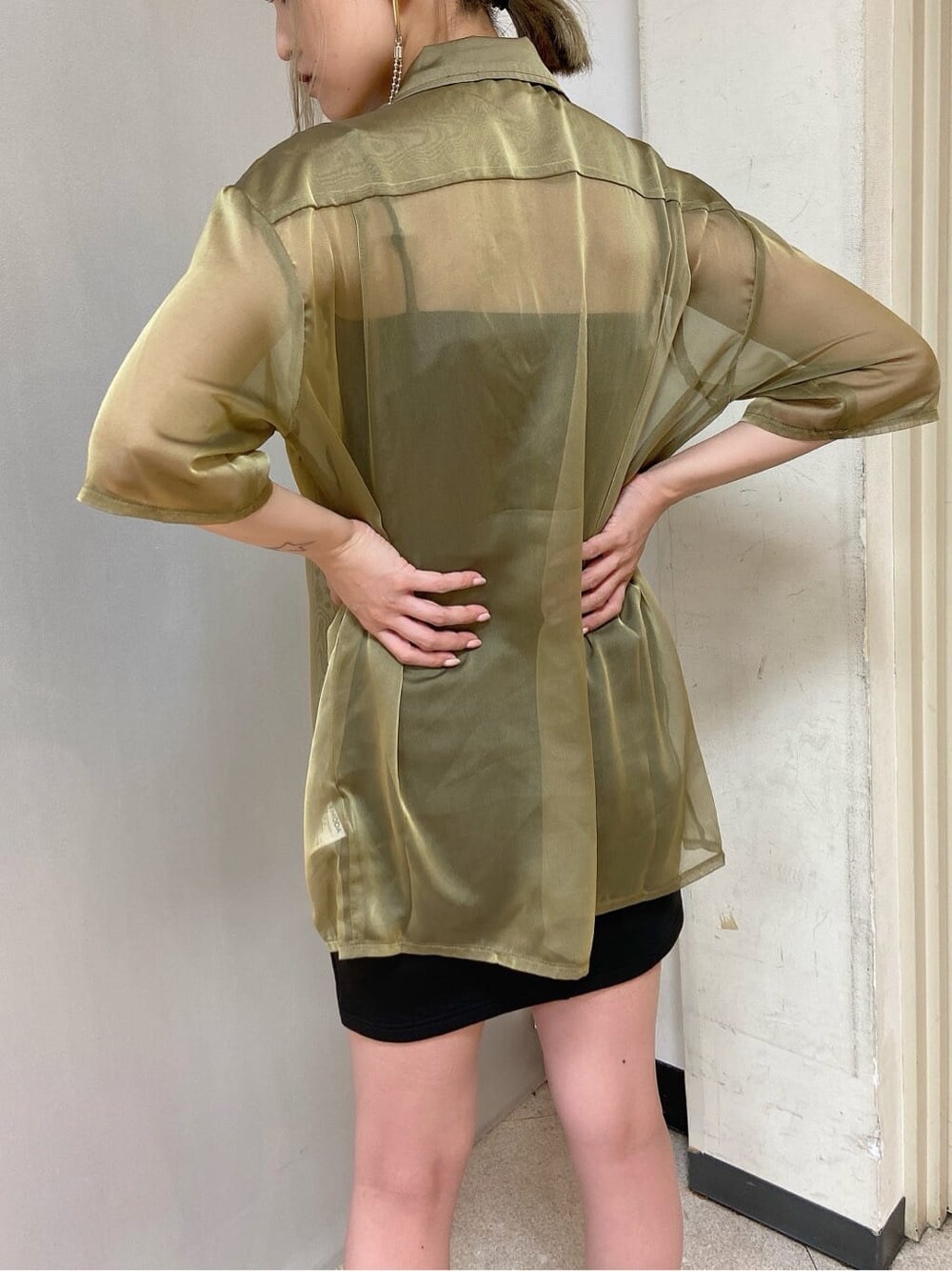 イエロー系のシャツ/ブラウス、ブラック系のスカート、ブラック系のサンダルを着用したレディースの夏コーディネートの3枚目の写真