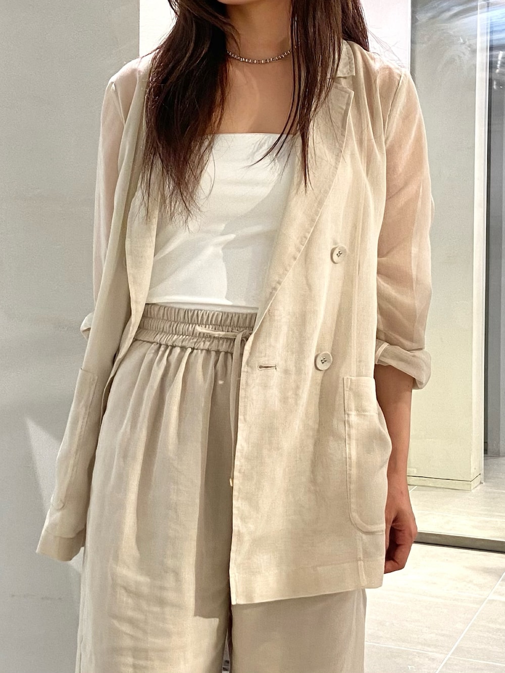 ホワイト系のテーラードジャケット、ホワイト系のその他パンツ、ブラック系のパンプスを着用したレディースの春コーディネートの5枚目の写真