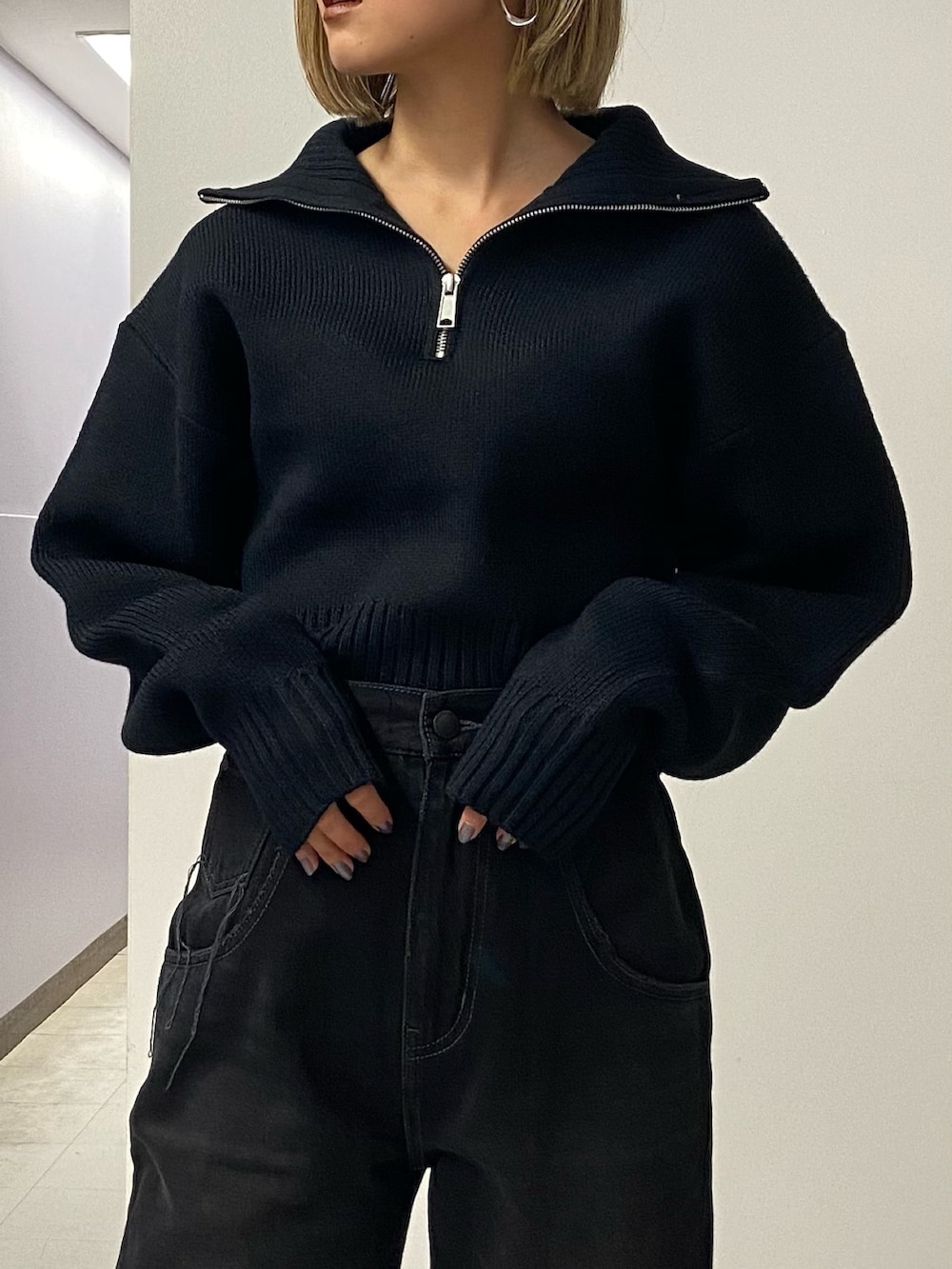 ブラック系のデニムパンツ、ブラック系のブーツ、ブラック系のニット/セーターを着用したレディースの秋コーディネートの5枚目の写真