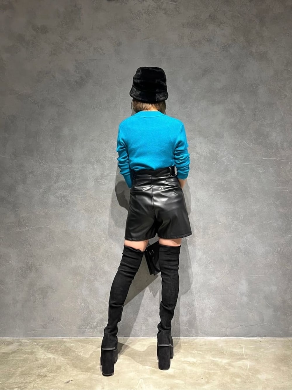 ブラック系のハンドバッグ、ブルー系のニット/セーター、ブラック系のその他パンツを着用したレディースの秋コーディネートの3枚目の写真