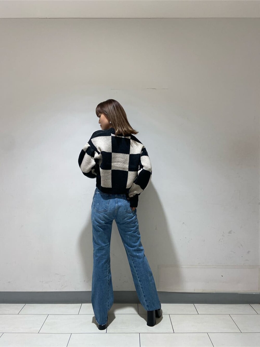 ブラック系のカーディガン/ボレロ、ブルー系のデニムパンツ、ブラック系のローファーを着用したレディースの冬コーディネートの4枚目の写真