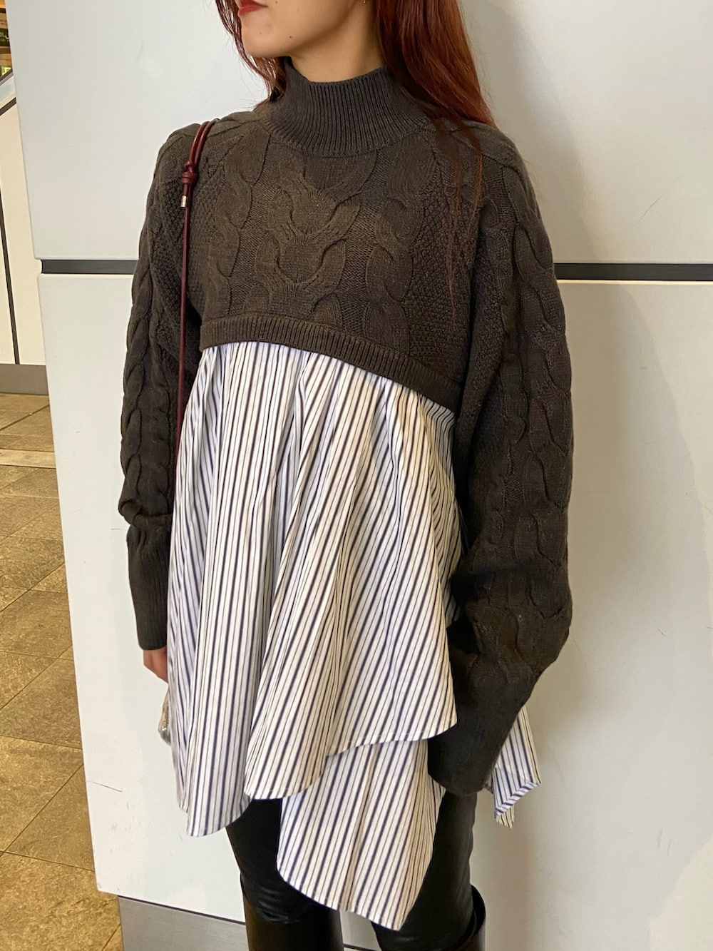 グレー系のブルゾン、ブラック系のブーツ、グレー系のニット/セーターを着用したレディースの秋コーディネートの4枚目の写真