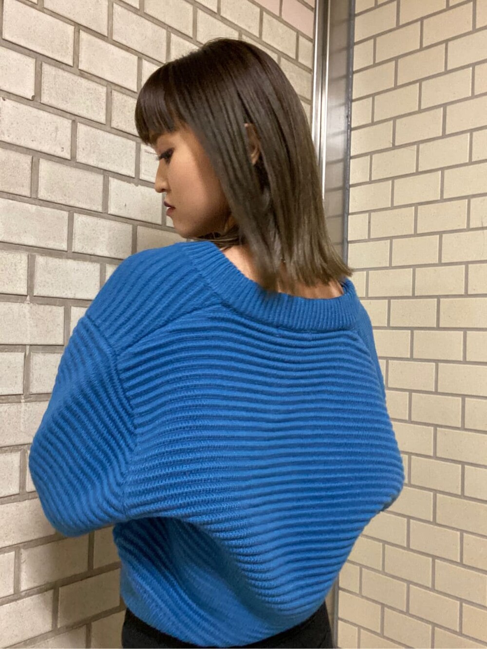 ブラック系のローファー、ブラック系のデニムパンツ、ブルー系のニット/セーターを着用したレディースの冬コーディネートの5枚目の写真