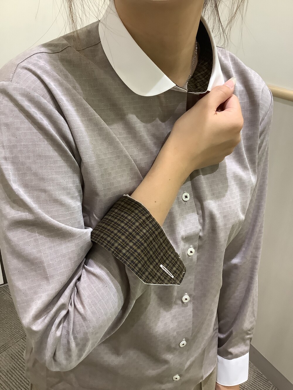 ブラウン系のビジネスシャツ、グレー系のベストを着用したレディースの秋コーディネートの3枚目の写真