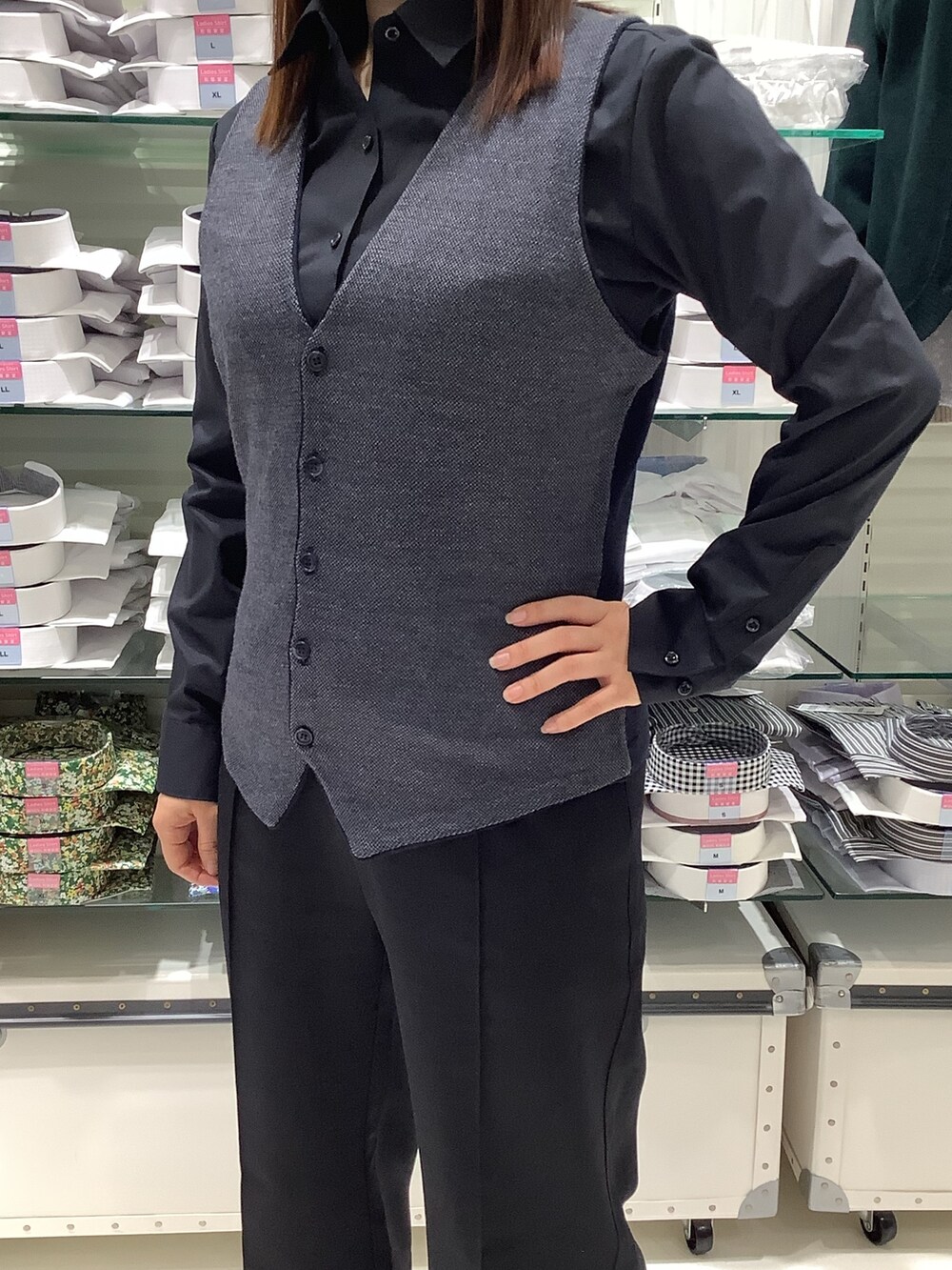 ブルー系のベスト、ブラック系のビジネスシャツを着用したレディースの秋コーディネートの2枚目の写真