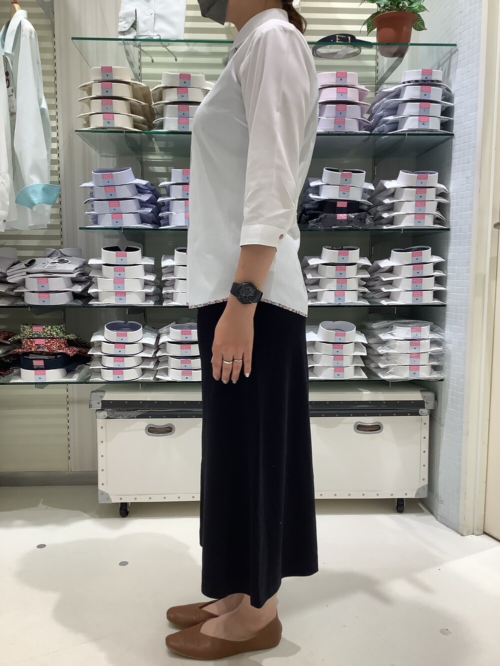 ホワイト系のビジネスシャツを着用したレディースの春コーディネートの3枚目の写真